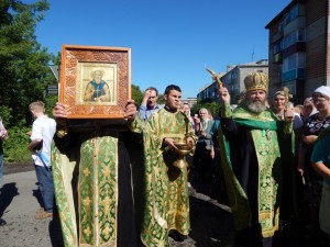 отец Михаил окропляет окрестности святой водой